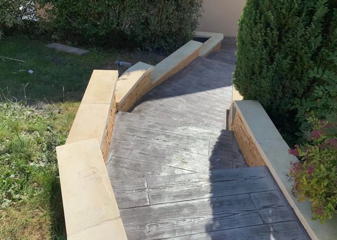 Rampa con escalones de hormigón impreso imitación madera en un jardín