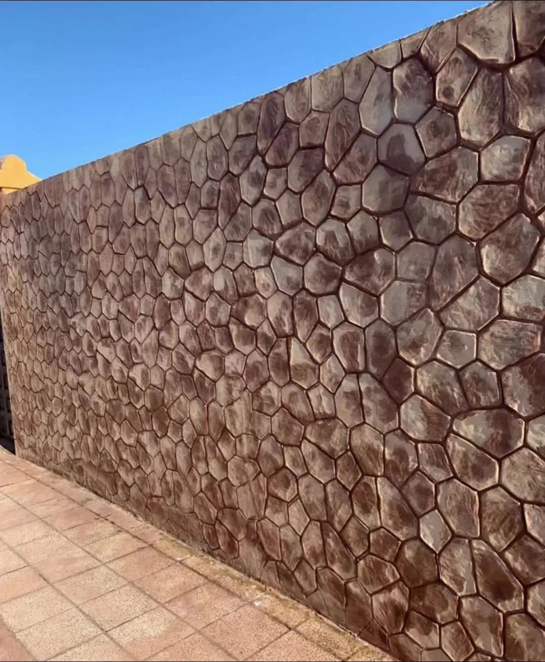 Muro alto revestido con relieve de piedra irregular